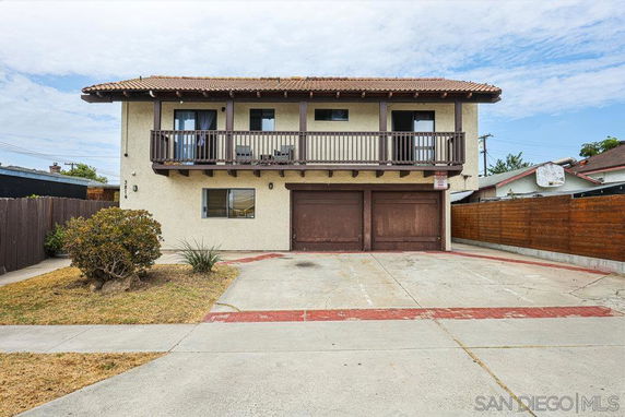 Front view of a two-story house with a double garage and a balcony.
