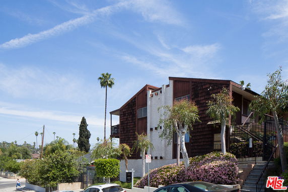 Front view of a multi-story building with wooden paneling and balconies.