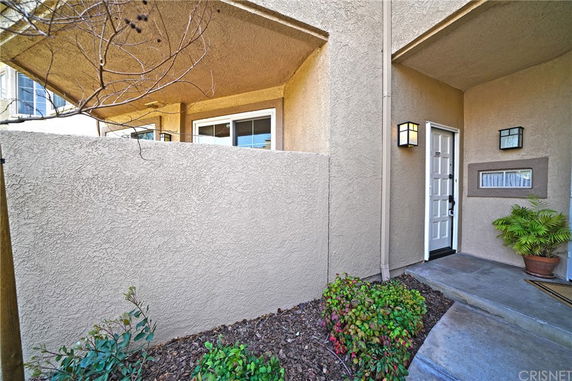 Front view of a house entrance with a walkway and decorative plants.