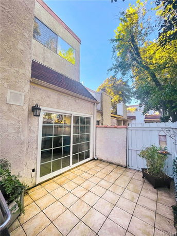 Exterior view of a two-story house with large windows and a patio.