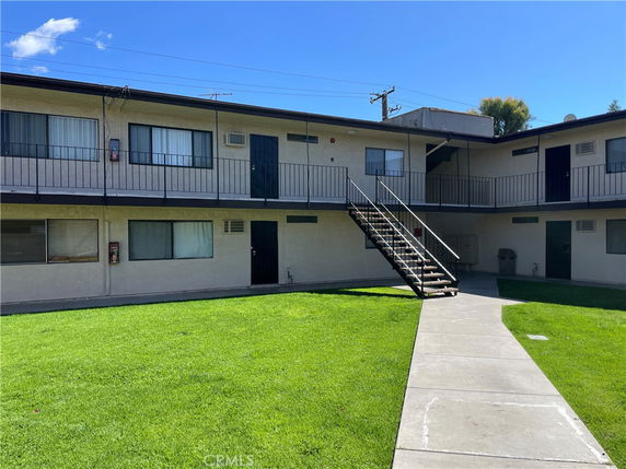 Front view of a two-story apartment building with external staircase.