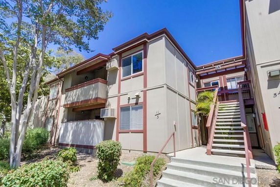 Front view of a multi-story apartment building with outdoor staircases and balconies.