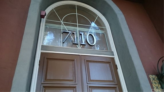 Front view close-up of a house entrance with an arched window above the door.