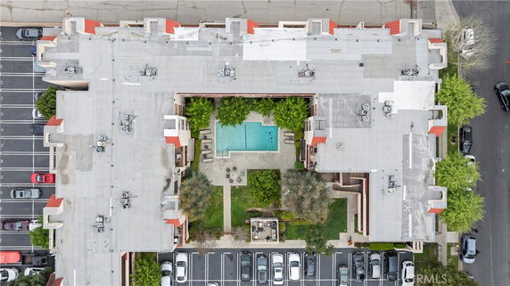 Aerial view of a building rooftop with multiple air conditioning units.