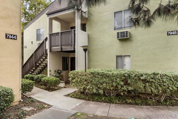 Front view of a two-story building with outdoor stairs and a small balcony.