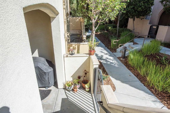 Exterior pathway and entrance to a residential building with landscaping.