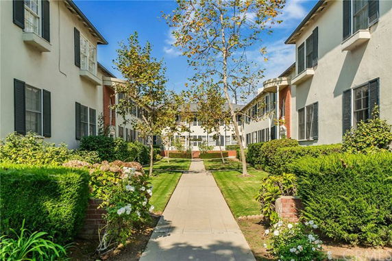 Front view of residential buildings with a walkway and garden area.