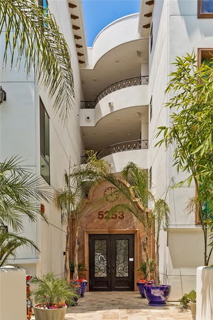 Front view of a multi-story building with a decorative entrance and balconies.