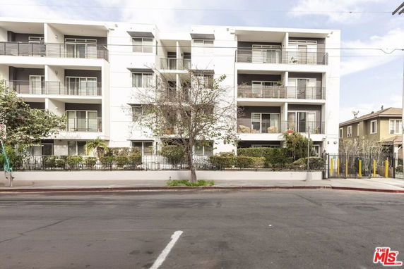 Front view of a multi-story apartment building with balconies.