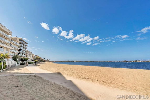 View of beachfront area with residential buildings and ocean.