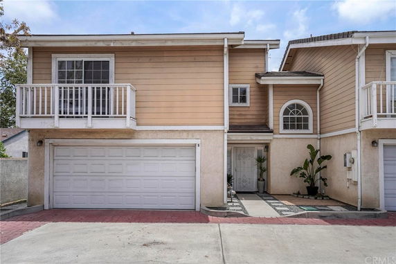 Front view of a two-story house with a balcony and double garage.