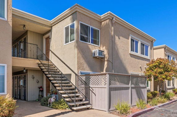 Front view of a two-story apartment building with external staircase.