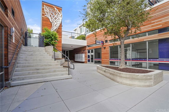 Front view of a modern commercial building with wooden panels and a staircase.