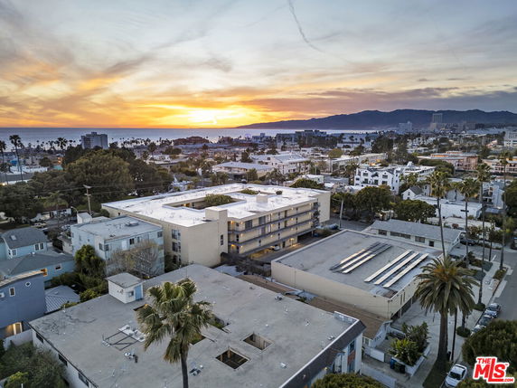 Aerial view of a residential area with multiple buildings and distant ocean.