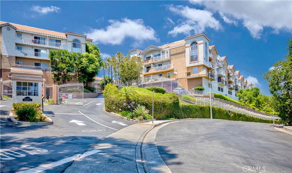 Front view of a multi-story residential building with gated entrance.
