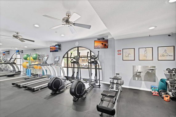 Interior view of a gym with exercise equipment including treadmills and elliptical machines.