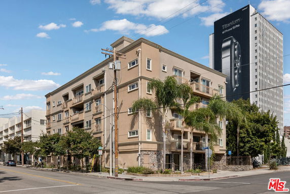 Front view of a multi-story apartment building with balconies.