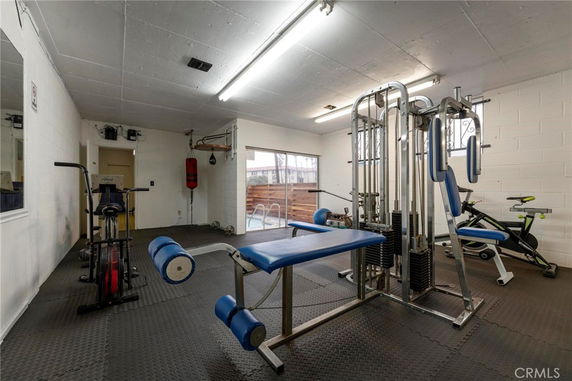Indoor gym area with exercise equipment, including a weight machine and stationary bikes.