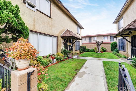 Front view of a two-story residential building with a walkway and garden.