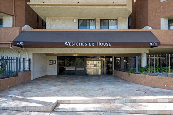 Entrance view of a building named Westchester House with a canopy and glass doors.