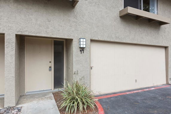 Front view of a house with a garage and a side entrance door.