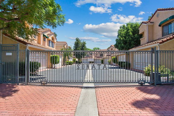 Front view of gated community entrance with two-story houses.