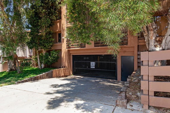 Front view of a multi-story building with a gated garage.