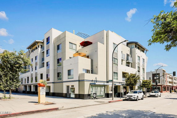 Front view of a multi-story modern apartment building on a city street.