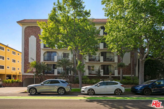 Front view of a multi-story apartment building with balconies.
