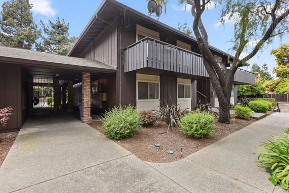 Front view of a two-story building with balcony and carport.