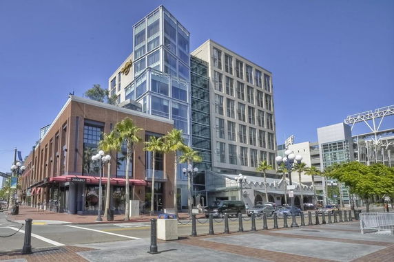 Front view of a multi-story building with a glass facade and attached retail space.