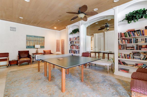 Room with a ping pong table and bookshelves.