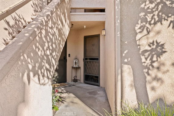 Entrance of a residential building with a staircase leading to the upper level.
