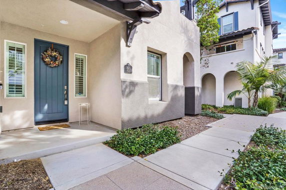 Front view of a house with a blue door and arched entryways.