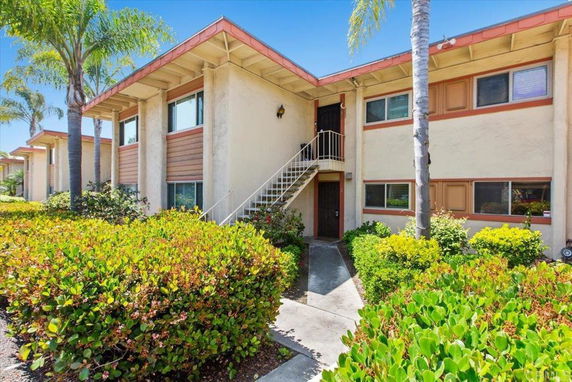 Front view of a two-story apartment building with a stairway leading to the upper floor.