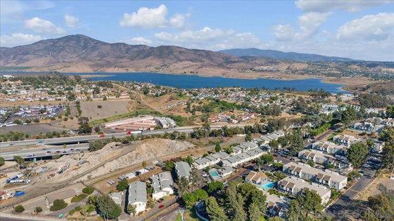 Panoramic view of a suburban area with a lake and mountains in the background