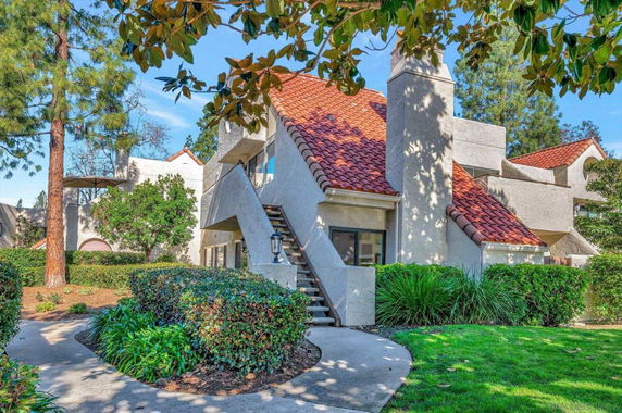 Front view of a multi-story house with red-tiled roof and external staircase.