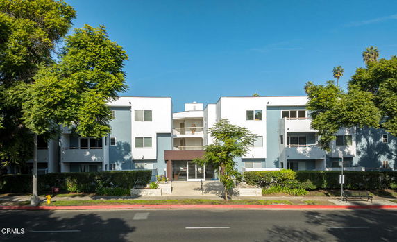 Front view of a multi-story apartment building with a central entrance.