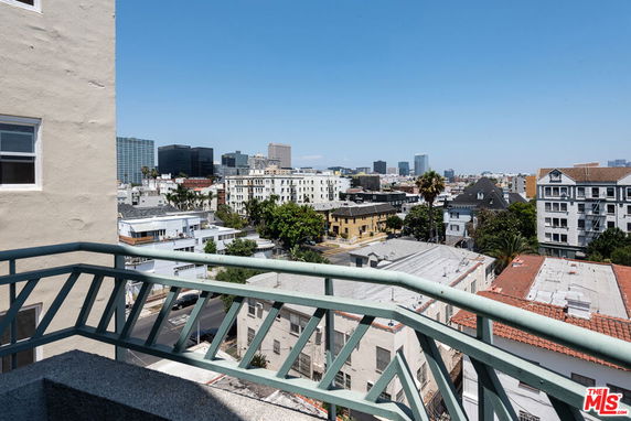 Panoramic view of buildings and cityscape seen from a balcony.