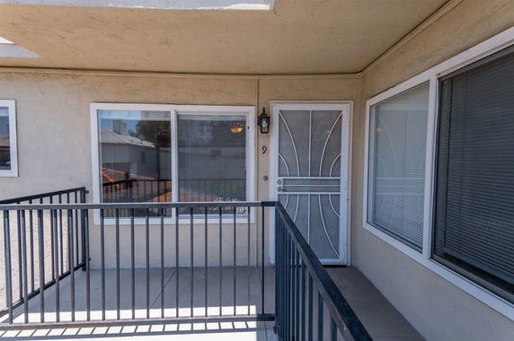 Front view of a building with a metal railing and a security door.