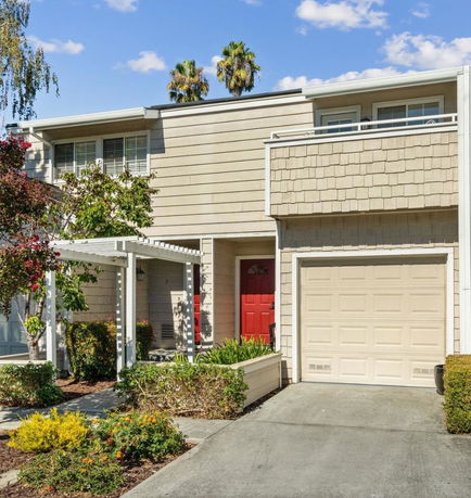 Front view of a two-story house with a garage and a red door.
