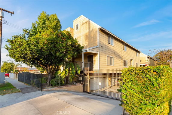 Front view of a multi-story residential building with gated entrance.