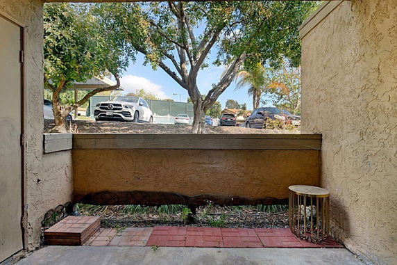 Outdoor view of a parking area with cars visible through a partially enclosed space.