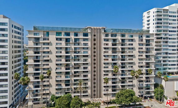 Front view of a multi-story apartment building with balconies.