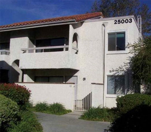 Front view of a two-story house with a white exterior and red-tiled roof.