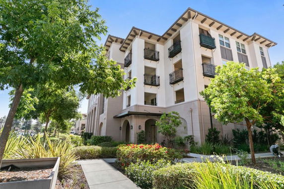 Front view of a multi-story apartment building with small balconies.