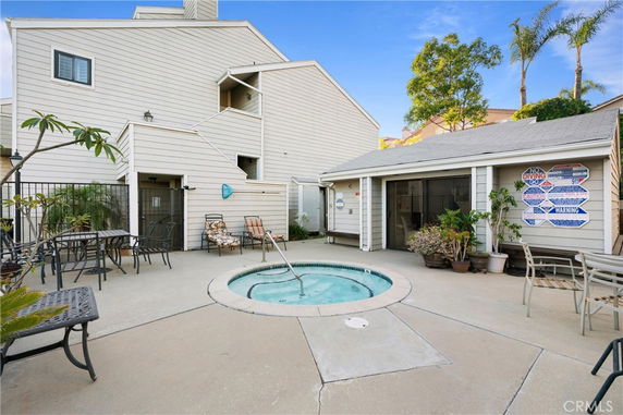Outdoor area with a small round swimming pool and seating, adjacent to a white building.