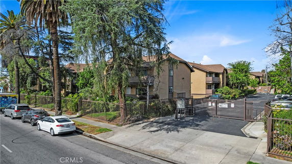 Front view of a multi-story residential building with a gated entrance.