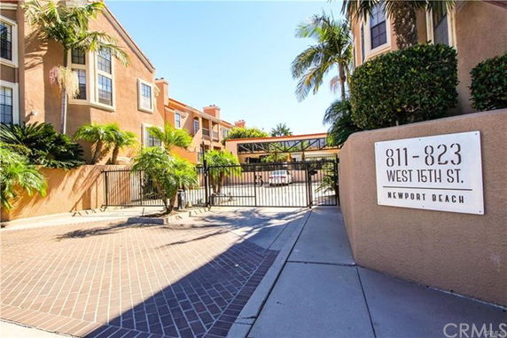 Front view of a multi-story residential building with gated entrance.