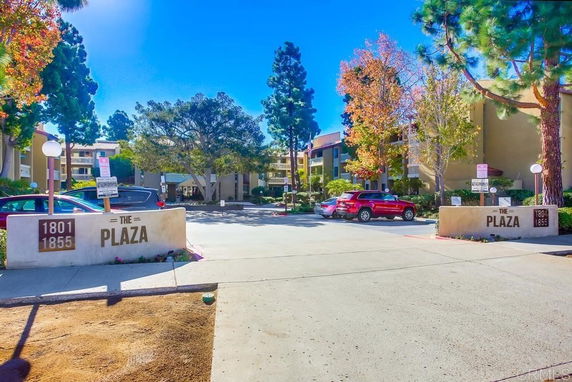 Front view of a multi-story complex named 'The Plaza' with visible parking spaces.